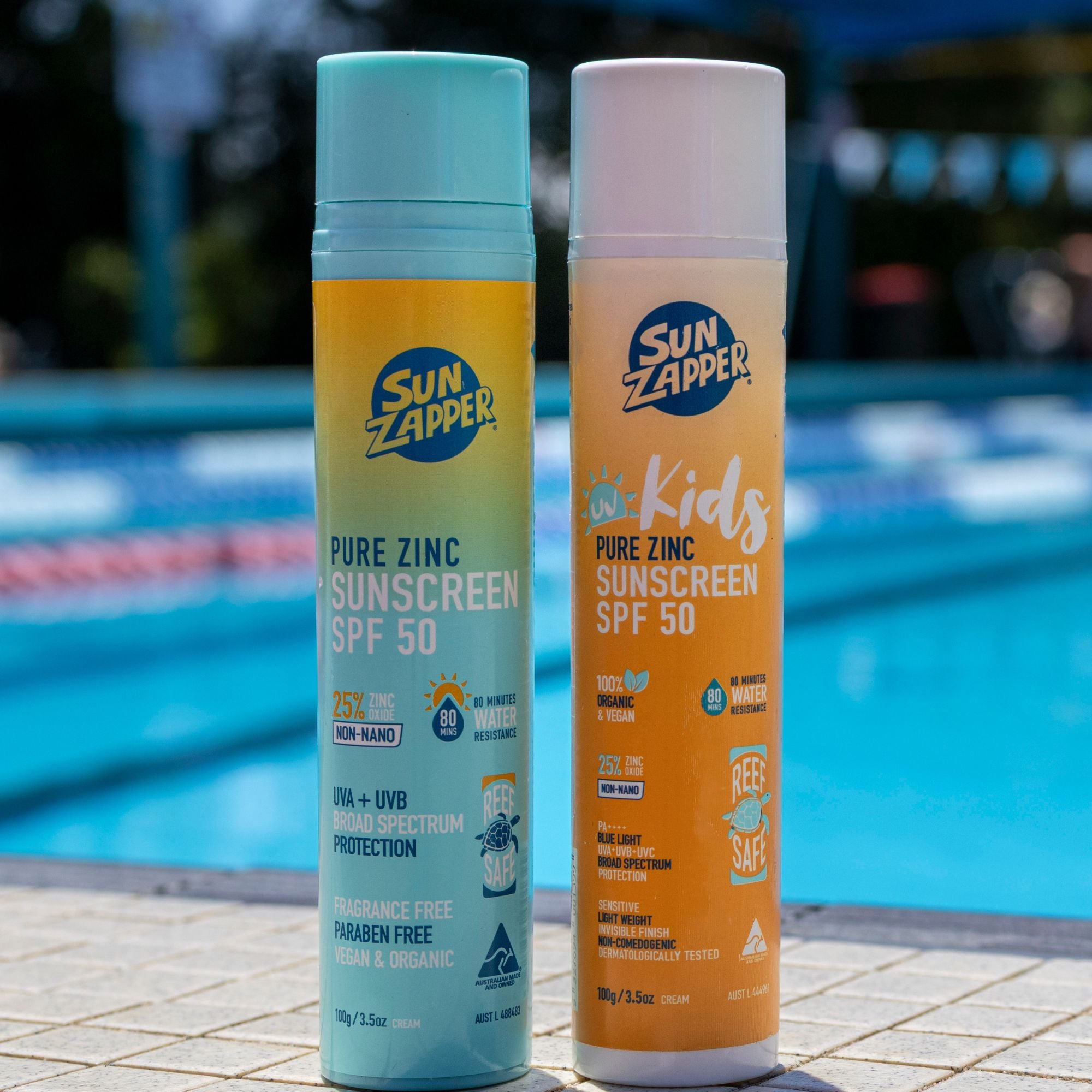 Two Sun Zapper sunscreen bottles by a pool