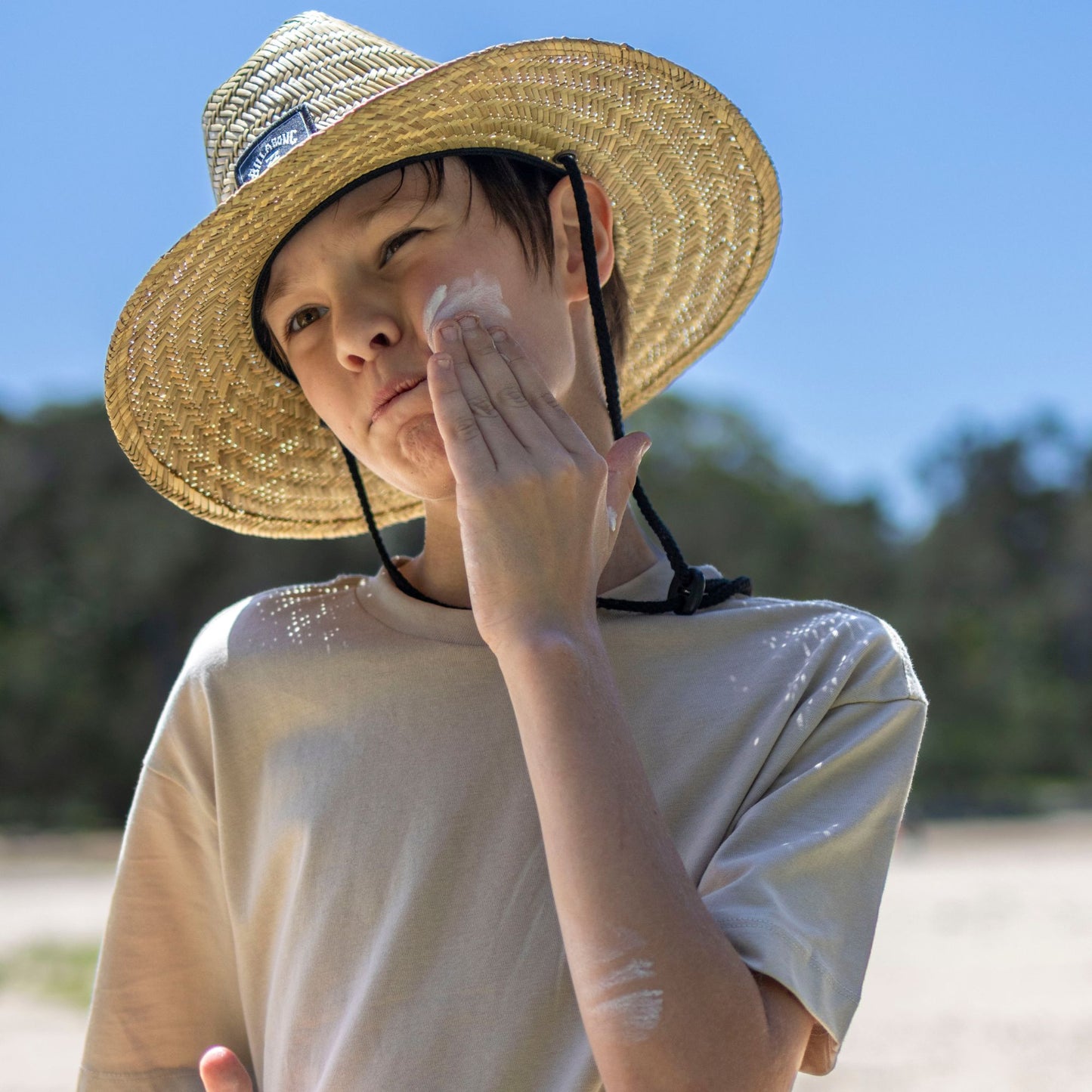 child applying natural sunscreen on a sunny day outdoors