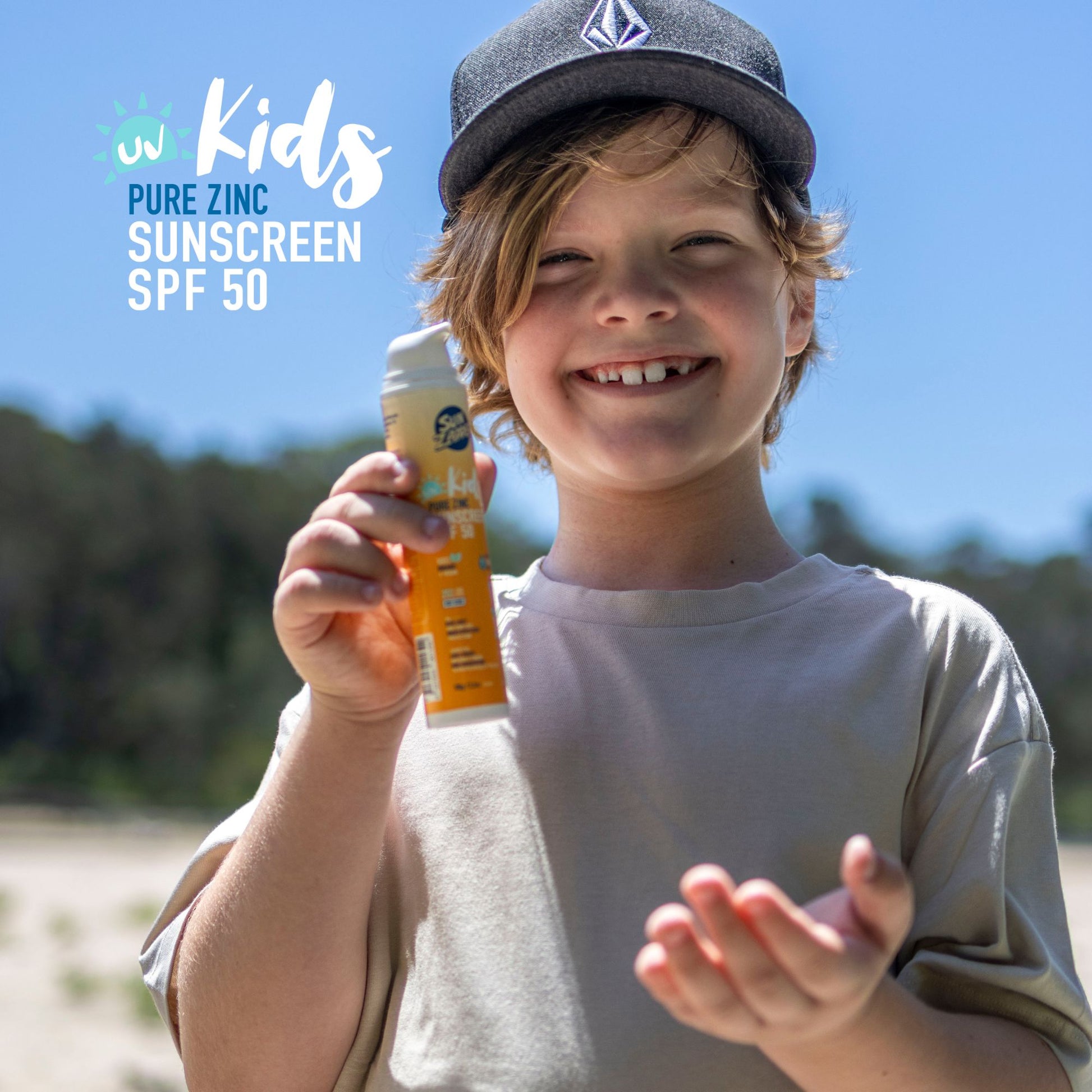 Child holding a bottle of Pure Zinc Kids Sunscreen SPF 50 on a sunny day.