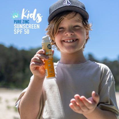 Child holding a bottle of Pure Zinc Kids Sunscreen SPF 50 on a sunny day.